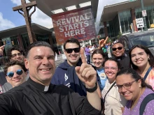 Father Rafael Capó (third from left) with young adults (from left) Alan Angelis, Arturo Zayas, Dylan Francisco, Rosanne Sherman, Cecilia Seiglie, Father Hilary Nwainya, Isabelle Seiglie, and Maria Vazquez at the National Eucharistic Congress outside of the Indianapolis Convention Center July 17, 2024.