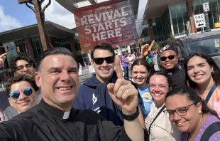 Father Rafael Capó (third from left) with young adults (from left) Alan Angelis, Arturo Zayas, Dylan Francisco, Rosanne Sherman, Cecilia Seiglie, Father Hilary Nwainya, Isabelle Seiglie, and Maria Vazquez at the National Eucharistic Congress outside of the Indianapolis Convention Center July 17, 2024. Credit: Antonio Dejesus