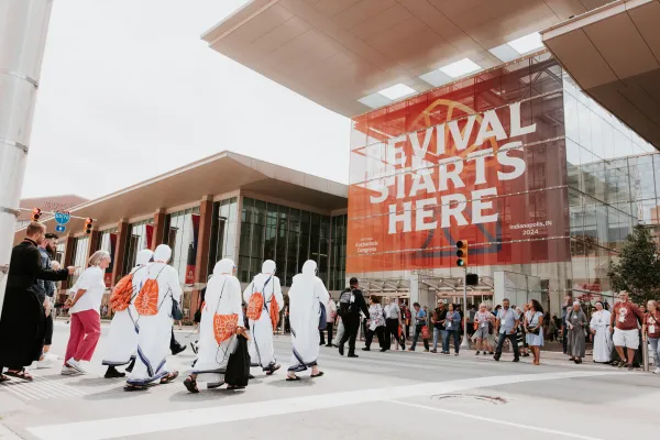 Sudionici Nacionalnog euharistijskog kongresa u Indianapolisu ulaze u Indiana Convention Center, gdje stoji znak 