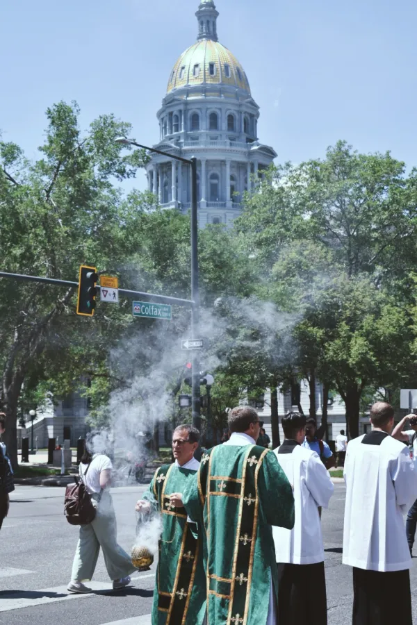 Svećenik širi tamjan tijekom euharistijske procesije, okrenut prema monstranci, dok ga drugi svećenik vodi ispred glavnog grada Colorada 9. lipnja 2024. Autor: Kate Quiñones/CNA