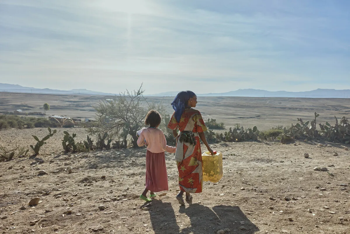 A woman and a girl in Tigray walk with supplies. The founder and CEO of the global school-feeding charity Mary’s Meals visited northern Ethiopia in March and confirmed reports of a widespread hunger crisis unfolding rapidly in Tigray in the aftermath of a two-year civil war and ongoing drought. ?w=200&h=150