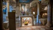 The interior of the Milk Grotto in Bethlehem. In the background, the most well-known depiction of Our Lady of the Milk. According to a Christian tradition dating back to the sixth century, the Virgin Mary was nursing the baby Jesus here, and when, in haste to flee to Egypt, she took him off her breast, a drop of milk fell to the ground, turning the stone completely white.