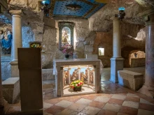 The interior of the Milk Grotto in Bethlehem. In the background, the most well-known depiction of Our Lady of the Milk. According to a Christian tradition dating back to the sixth century, the Virgin Mary was nursing the baby Jesus here, and when, in haste to flee to Egypt, she took him off her breast, a drop of milk fell to the ground, turning the stone completely white.