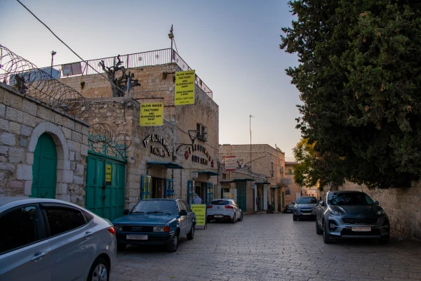 Milk Grotto Street in Bethlehem, the artisans' street, in December 2024. This street is lined with many shops and workshops of local artisans, including the ones of Jack Giacaman and his cousin Bassem Giacaman (in the photo). For more than one year it has been completely empty. Credit: Marinella Bandini