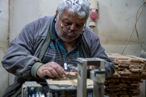 A worker cuts crosses in Robert Giacaman's workshop in Bethlehem in December 2024. “We get some requests, but not like before. We try to give work to our employees. Many can no longer support their families or their children's education... an entire generation is being lost,” Giacaman told CNA. Credit: Marinella Bandini