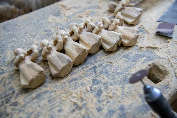 A row of angels on a workbench in Robert Giacaman's woodcraft workshop in Bethlehem, waiting to be finished, in December 2024. Credit: Marinella Bandini