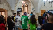 A group of young people from the Apostolic Movement of Jish, led by Father Sandy Habib, during prayer before the meal on July 12, 2024, at the Maronite convent in Jerusalem. The aim is “bringing ourselves closer to Jesus,” Habib explained to CNA. “We try to achieve this through spiritual activities, social activities like trips, and by announcing Jesus Christ.”