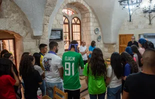 A group of young people from the Apostolic Movement of Jish, led by Father Sandy Habib, during prayer before the meal on July 12, 2024, at the Maronite convent in Jerusalem. The aim is “bringing ourselves closer to Jesus,” Habib explained to CNA. “We try to achieve this through spiritual activities, social activities like trips, and by announcing Jesus Christ.” Credit: Marinella Bandini