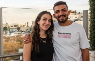 Sabeen Rahil and Elias Johny Al Arja in Bethlehem. In the background behind them is the bell tower of the Church of the Nativity, which stands on the site where Jesus was born. Credit: Marinella Bandini