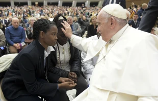 Pope Francis blesses a young woman during a general audience in the Vatican's Paul VI Hall in December 2022. Vatican Media.