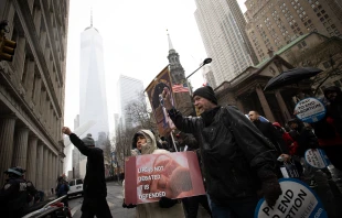 Michael Phelps of Good Counsel Homes prays the rosary with others as they pass Trinity Church in the shadow of the Freedom Tower in Lower Manhattan on March 25, 2023. Credit: Jeffrey Bruno/CNA