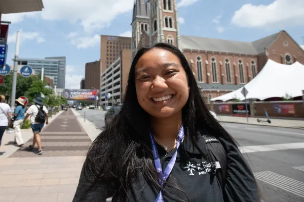 Jaella Mac Au, one of the Perpetual Pilgrims, in front of St. John the Evangelist Catholic Church, the endpoint of the National Eucharistic Pilgrimages. Credit: Jeffrey Bruno