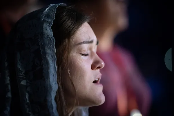 A National Eucharistic Congress attendee sings during Eucharistic adoration. Credit: Jeffrey Bruno