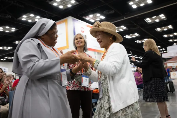 A religious sister and a laywoman share a moment of joy at the expo hall at the Indiana Convention Center during the National Eucharistic Congress. Credit: Jeffrey Bruno