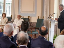 Pope Francis sits next to Queen Mathilde and listens as King Philippe (far right) speaks during a meeting between the pope and dignitaries in the Grand Gallery of Belgium’s Laeken Castle on Friday, Sept. 27, 2024.