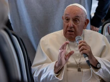 Pope Francis speaks aboard the papal plane on Sunday, Sept. 29, 2024.