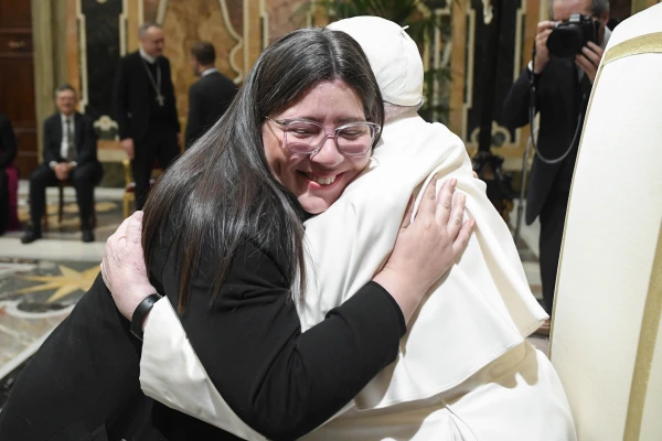 Pope Francis is hugged by a visitor at a meeting with Church communications officials at the Vatican, Monday, Jan. 27, 2025. Credit: Vatican Media