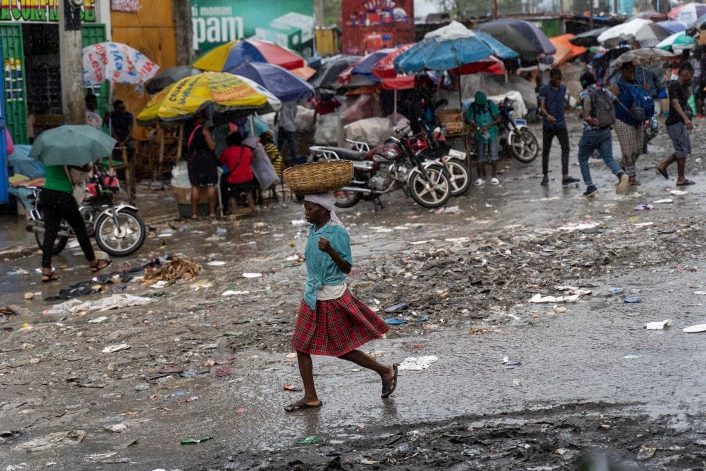 A woman walks in the rain in Port-au-Prince, Haiti, on Oct. 24, 2022. The United Nations Security Council is considering an international intervention in Haiti to open up an aid corridor.?w=200&h=150