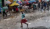 A woman walks in the rain in Port-au-Prince, Haiti, on Oct. 24, 2022. The United Nations Security Council is considering an international intervention in Haiti to open up an aid corridor.