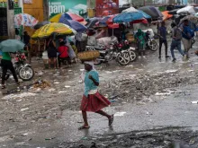 A woman walks in the rain in Port-au-Prince, Haiti, on Oct. 24, 2022. The United Nations Security Council is considering an international intervention in Haiti to open up an aid corridor.