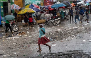 A woman walks in the rain in Port-au-Prince, Haiti, on Oct. 24, 2022. The United Nations Security Council is considering an international intervention in Haiti to open up an aid corridor. Credit: Richard Pierrin/AFP via Getty Images