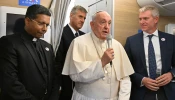 Pope Francis addresses journalists aboard the papal plane heading to Mongolia, with Cardinal-elect George Jacob Koovakad at left, on Aug. 31, 2023.