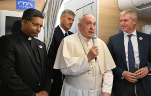 Pope Francis addresses journalists aboard the papal plane heading to Mongolia, with Cardinal-elect George Jacob Koovakad at left, on Aug. 31, 2023. Credit: Alberto PIZZOLI/POOL/AFP