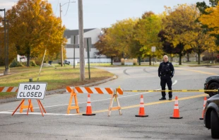 A police officer blocks access to the road to Sparetime Recreation on Oct. 26, 2023, in Lewiston, Maine. Police are still searching for the suspect in the mass shooting, Robert Card. Credit: Scott Eisen/Getty Images