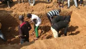 This image grab made from an AFPTV video taken in Maiyanga village in Bokkos local government on Dec. 27, 2023, shows families burying in a mass grave their relatives killed in deadly attacks conducted by armed groups in Nigeria's central Plateau state.