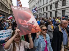 Protesters hold a placard depicting an unborn baby as they take part in the March of Life in Warsaw, on April 14, 2024.