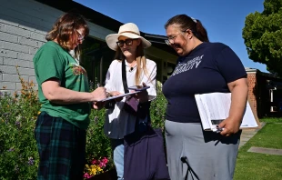 Volunteer canvassers Liz Grumbach (center) and Patricia Jones meet Lucy Meyer (left), who signs a petition outside her home in Phoenix on April 13, 2024, as the volunteers go door-to-door for signatures to get the petition for the Arizona Abortion Access Act onto the November 2024 ballot for voters to decide. Credit: FREDERIC J. BROWN/AFP via Getty Images