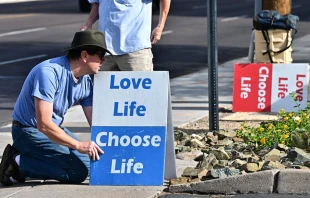 Pro-life activist Matthew Engelthaler places signs in front of Camelback Family Planning, an abortion clinic in Phoenix, on April 18, 2024. Credit: FREDERIC J. BROWN/AFP via Getty Images