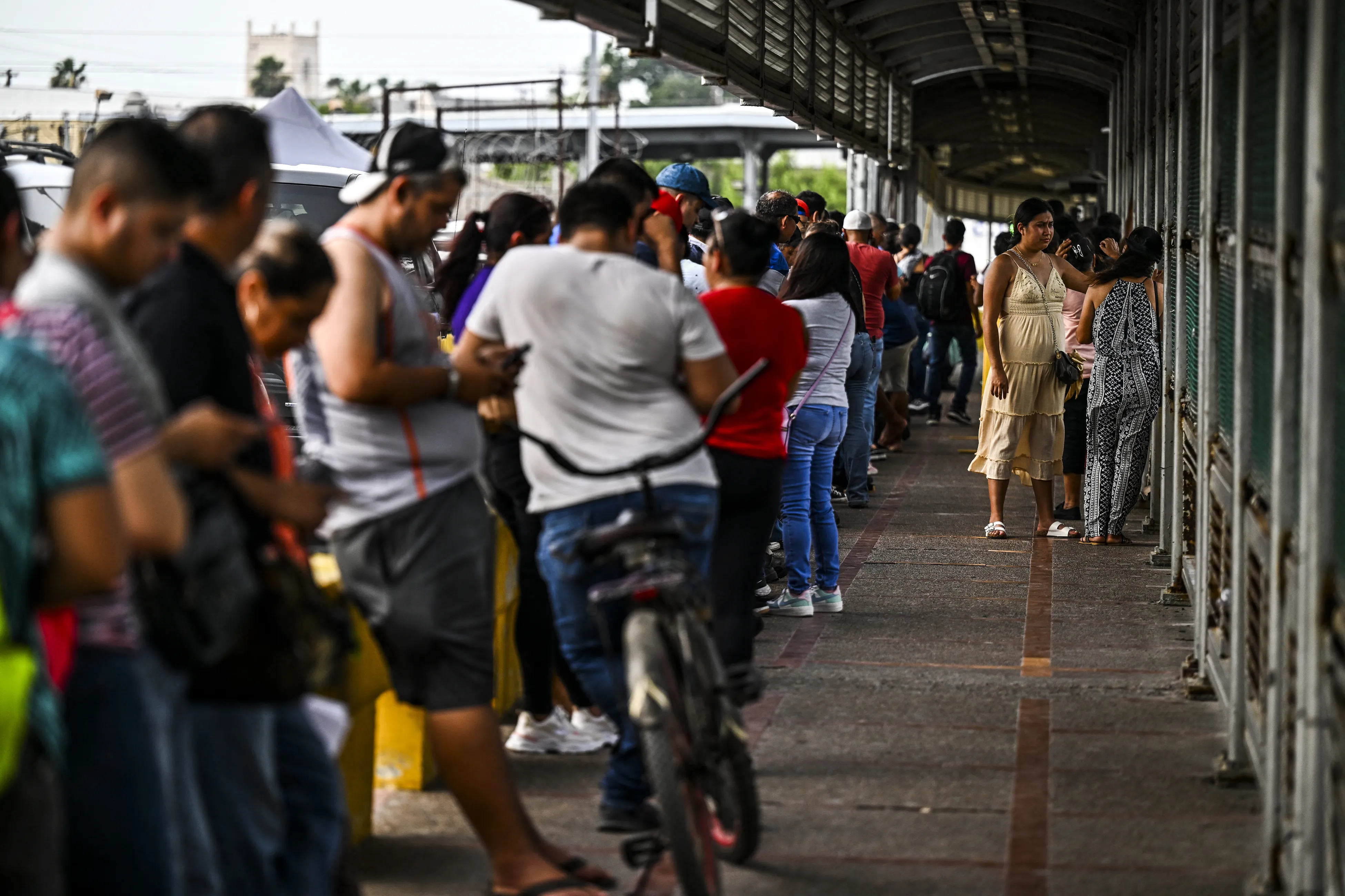 Migrants mostly form Central America wait in line to cross the border at the Gateway International Bridge into the U.S. from Matamoros, Mexico, to Brownsville, Texas, on June 4, 2024.?w=200&h=150