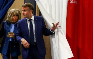 French President Emmanuel Macron and his wife, Brigitte Macron, exit a polling booth adorned with curtains displaying the colors of the flag of France before casting their ballot for the European Parliament election at a polling station in Le Touquet, northern France, on June 9, 2024. Credit: HANNAH MCKAY/POOL/AFP via Getty Images