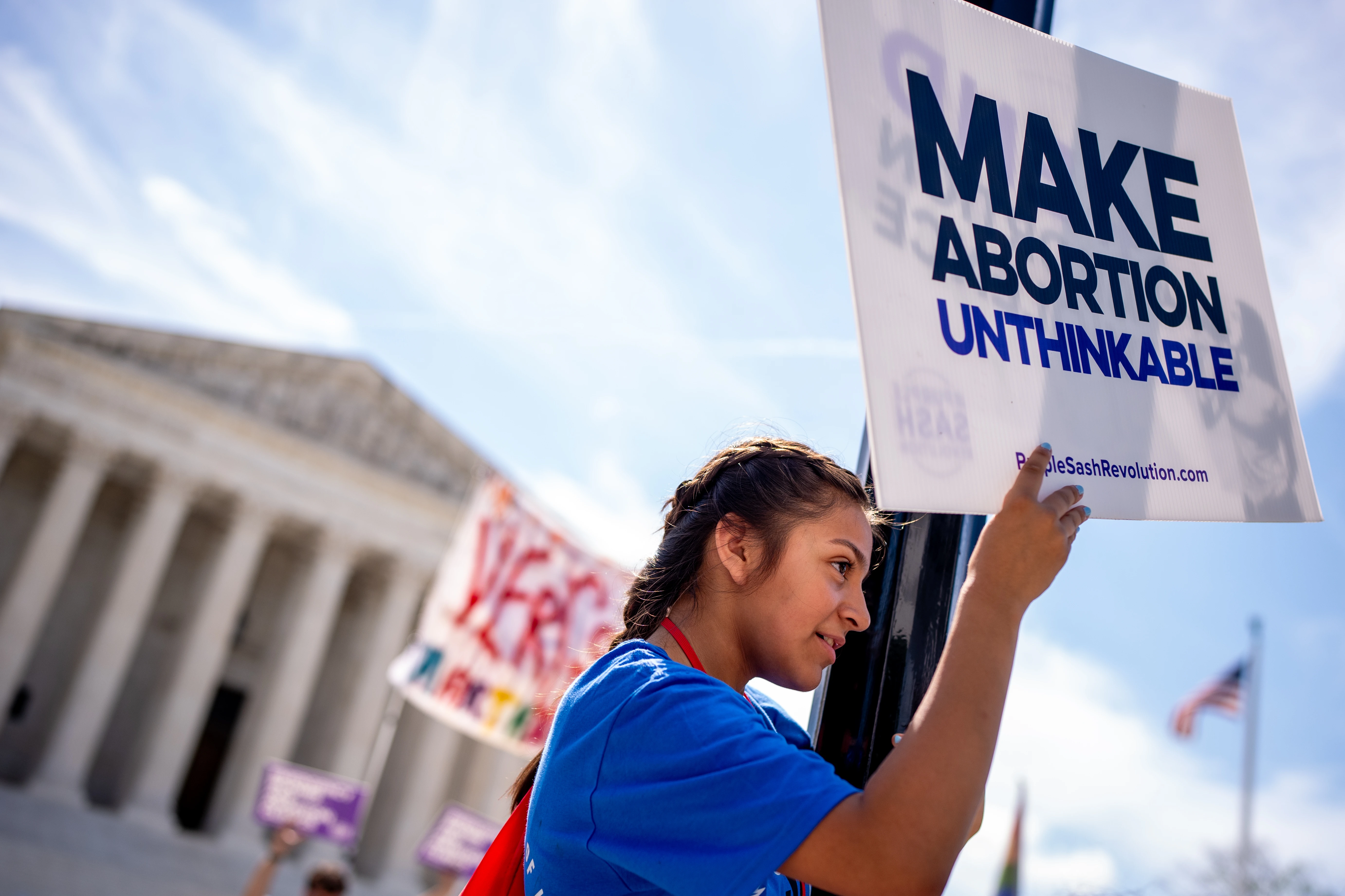 A pro-life supporter stands on a lamppost and holds a sign that reads "MAKE ABORTION UNTHINKABLE" in front of the Supreme Court on June 20, 2024, in Washington, D.C.?w=200&h=150