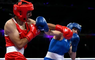 Algeria's Imane Khelif (in red) punches Italy’s Angela Carini in the women’s 66kg preliminaries round of 16 boxing match during the Paris 2024 Olympic Games at the North Paris Arena in Villepinte on Aug. 1, 2024. Credit: MOHD RASFAN/AFP via Getty Images