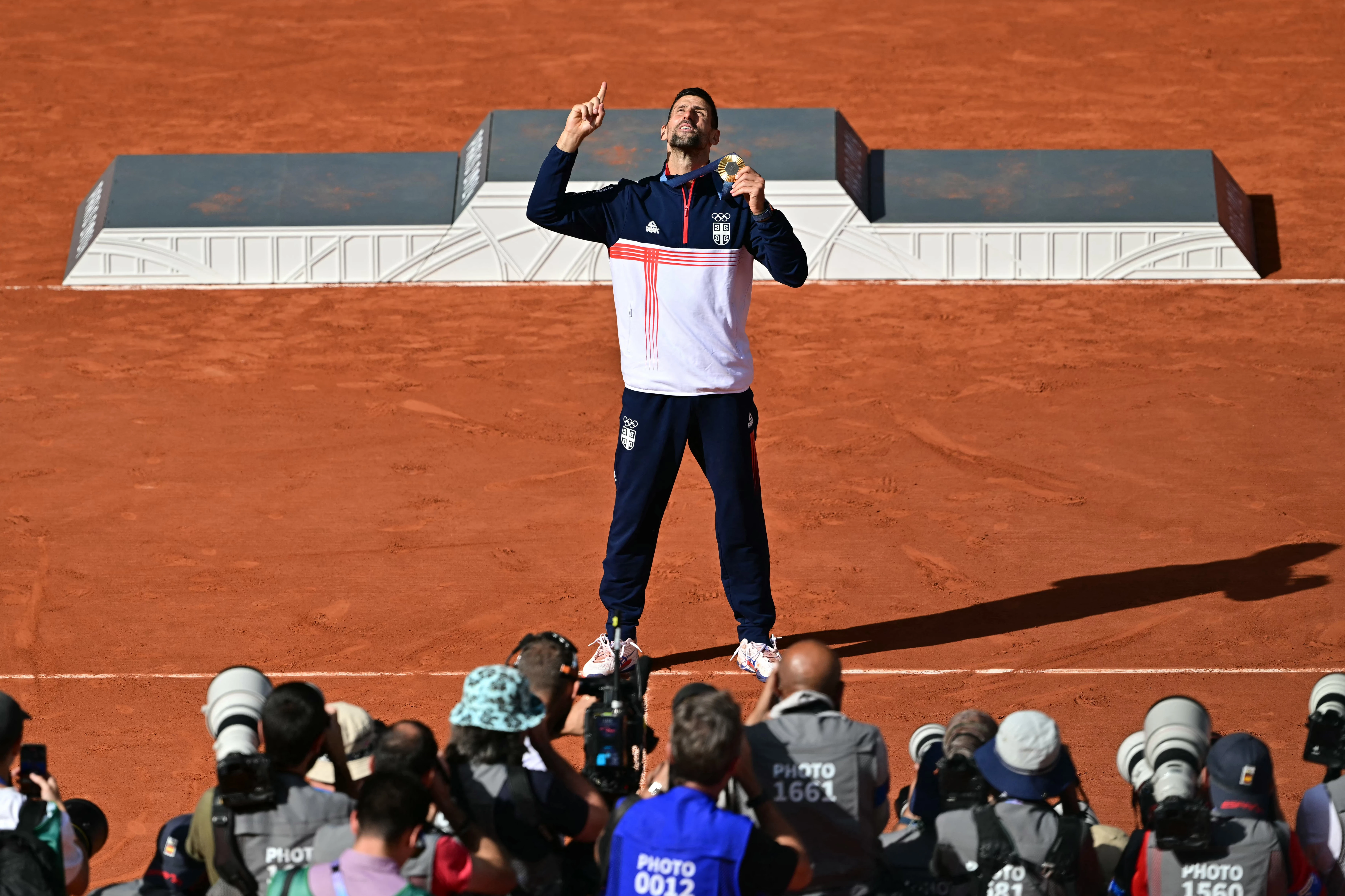 Gold medalist Novak Djokovic of Serbia poses for photographers with his medal at the presentation ceremony for the men's singles tennis event on Court Philippe-Chatrier at the Roland-Garros Stadium during the Paris 2024 Olympic Games on Aug. 4, 2024.?w=200&h=150