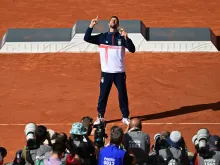 Gold medalist Novak Djokovic of Serbia poses for photographers with his medal at the presentation ceremony for the men's singles tennis event on Court Philippe-Chatrier at the Roland-Garros Stadium during the Paris 2024 Olympic Games on Aug. 4, 2024.