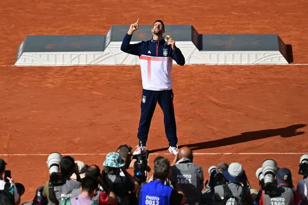 Gold medalist Serbia's Novak Djokovic poses for photographers with his medal at the presentation ceremony for the men's singles tennis event on Court Philippe-Chatrier at the Roland-Garros Stadium during the Paris 2024 Olympic Games on Aug. 4, 2024. Credit: Miguel Medina/AFP/Getty Images