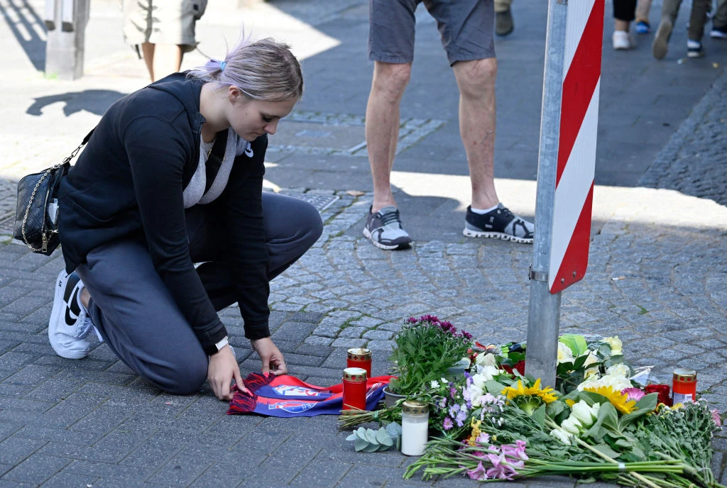 A woman kneels at a makeshift memorial of flowers and candles for the victims on Aug. 24, 2024, close to the scene where at least three people were killed and several injured when a man attacked them with a knife on Aug. 23, 2024, in Solingen, western Germany, during a festival to mark the city’s 650th anniversary.?w=200&h=150