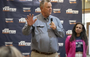 Sen. Jon Tester, D-Montana, speaks as Planned Parenthood Action Fund President and CEO Alexis McGill Johnson (right) looks on during a rally on Sept. 5, 2024, in Bozeman, Montana. The Right to Abortion Initiative will be on the Nov. 5 ballot as an amendment to Montana’s constitution. Tester attended the rally in support of the initiative. Credit: William Campbell/Getty Images