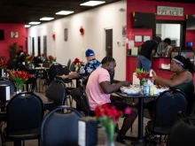 Haitians sit down to eat their meal at a Haitian restaurant in Springfield, Ohio, on Sept. 12, 2024.