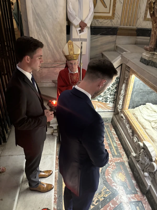 Former NBA All-Star Gordon Hayward venerates the tomb of St. Sebastian in Rome as Archbishop Timothy Broglio and Maxwell Van Vliet, Haward’s sponsor, look on. Credit: Courtesy of the Archdiocese for the Military Services USA