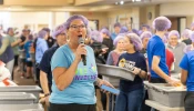 Lori Stillwell, a volunteer and a member of the local Kiwanis Club, directs nearly 600 volunteers who gathered Nov. 2, 2024, at St. Isidore Parish in Macomb, Michigan, to package 100,000 meals in partnership with the Kids Coalition Against Hunger. The massive annual effort brought together volunteers from the Disciples Unleashed Family of Parishes as well as the local community to aid victims of natural disasters, including the recent hurricanes in the U.S. South.