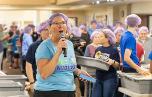 Lori Stillwell, a volunteer and a member of the local Kiwanis Club, directs nearly 600 volunteers who gathered Nov. 2, 2024, at St. Isidore Parish in Macomb, Michigan, to package 100,000 meals in partnership with the Kids Coalition Against Hunger. The massive annual effort brought together volunteers from the Disciples Unleashed Family of Parishes as well as the local community to aid victims of natural disasters, including the recent hurricanes in the U.S. South. Credit: Steven Stechschulte/Special to Detroit Catholic