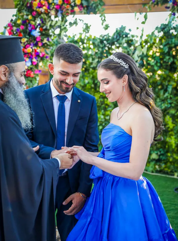 Sabeen Rahil places the ring on Elias Al Arj's finger during the engagement ceremony in Bethlehem on Aug. 3, 2024. After that, the priest said something along the lines of “You’re bound together.” Credit: Photo courtesy of Sabeen Rahil and Elias Al Arja