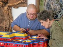 John Kraemer shows off the interior of one of his Lego churches to an interested parishioner at Resurrection of the Lord Parish in Standish, Michigan.