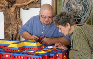 John Kraemer shows off the interior of one of his Lego churches to an interested parishioner at Resurrection of the Lord Parish in Standish, Michigan. Credit: Photo courtesy of John Kraemer