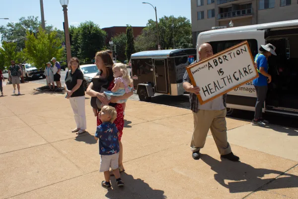 A young Catholic mother attempts to block a pro-abortion sign outside the Cathedral Basilica of St. Louis on July 7, 2024. Credit: Jonah McKeown/CNA