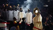 Father Boniface Hicks, O.S.B., a sought-after spiritual director and retreat master, processes the massive golden monstrance containing the Eucharist into the midst of the assembled crowd in Lucas Oil Stadium.